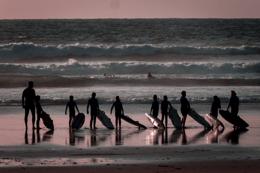 Surfers on the beach at sun down